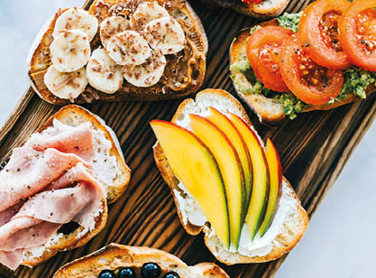Delicious healthy toasts mix for breakfast, lunch or snack on a wooden board, top view 