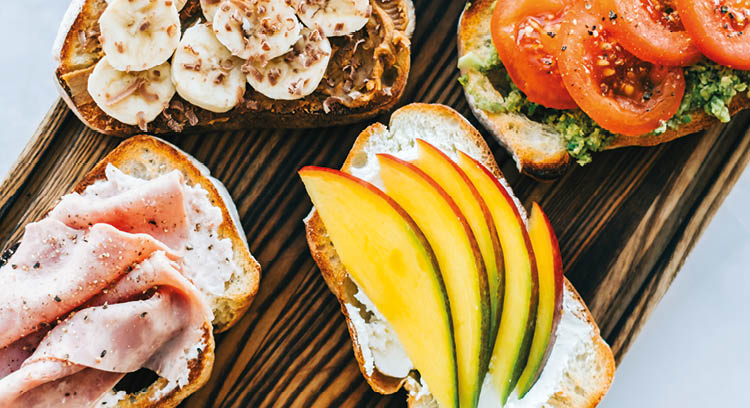 Delicious healthy toasts mix for breakfast, lunch or snack on a wooden board, top view 