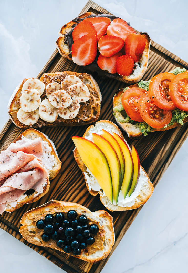 Delicious healthy toasts mix for breakfast, lunch or snack on a wooden board, top view 